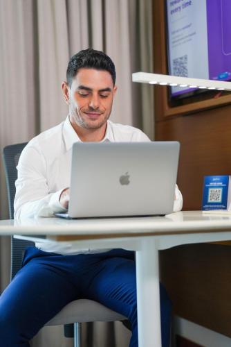 a man sitting at a table with a laptop computer at Radisson Hotel Colombo in Colombo