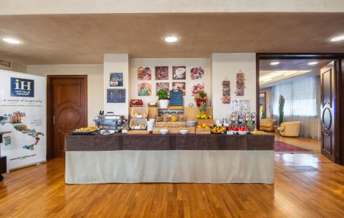 a lobby with a food counter in a building at iH Hotels Padova Admiral in Padova