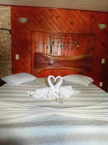 a bedroom with a bed with two swans on it at Suite JC in Visconde De Maua