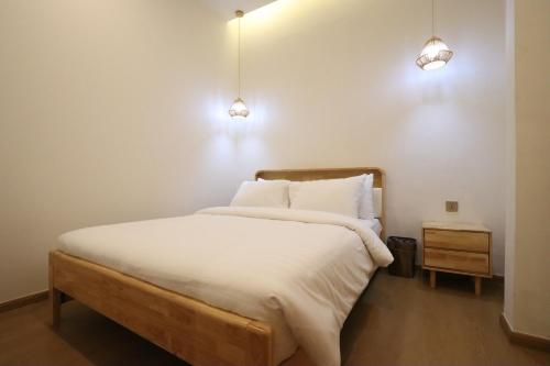 a bedroom with a bed with two lights on the wall at Casabella Homestay 302 Batam Penuin in Nagoya