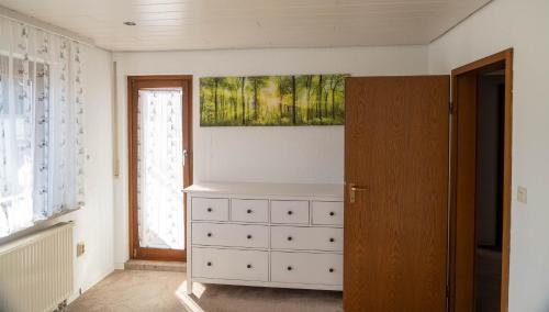 a bedroom with a dresser and a painting on the wall at Hotel & Restaurant Zum Reussenstein in Böblingen