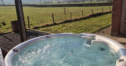 a bath tub with a view of a field at Bowland Breaks-A Luxury Barn Conversion with Optional Hot Tub, Log burner and countryside views in Longridge