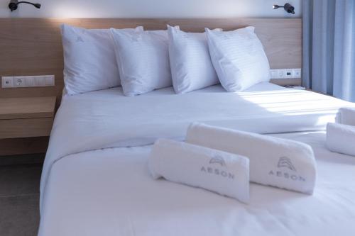 a bedroom with two beds with white sheets and pillows at Aeson Premium Living in Volos