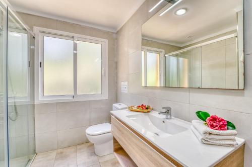 a bathroom with a sink and a toilet and a mirror at Ideal Property Mallorca - Tacaritx in Cielo de Bonaire 