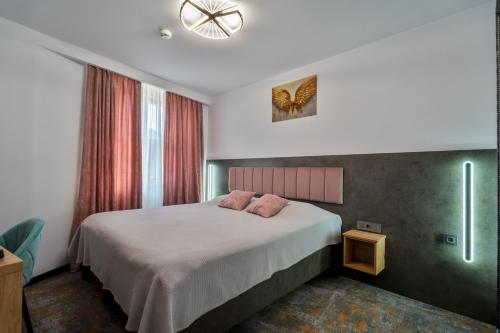 a bedroom with a bed with two pillows on it at La Borsanu in Năsăud