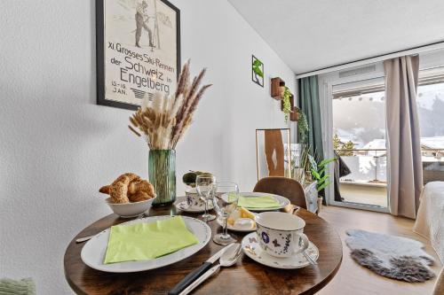 a table with a plate of food on it at Zentrales Studio mit mega Bergblick, Titlis, Luzern, Lake, Kurpark in Engelberg