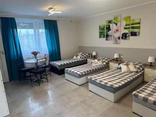 a living room with three beds and a table at Noclegi Witnica in Witnica