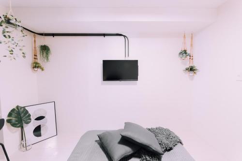 a white room with a bed and a tv at Minimalist Loft Namba Compact Studio with a 24-hour Gym MA1001 in Osaka