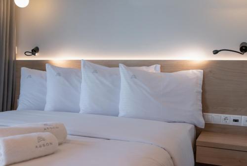 a bed with white pillows and two towels on it at Aeson Premium Living in Volos