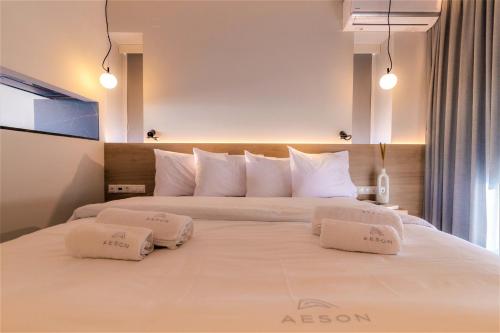 a large white bed with two white pillows on it at Aeson Premium Living in Volos