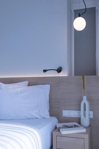 a bedroom with a bed with a white vase on a table at Aeson Premium Living in Volos