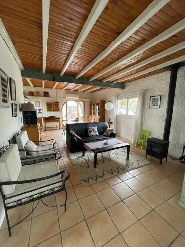 a living room with a couch and a table at Charming house with garden terrace and barbecue in Saint-Cricq