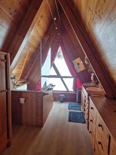 an attic bathroom with a large window and a sink at le chalet pointu de capucine in Bourg-Saint-Maurice