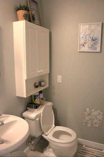a bathroom with a white toilet and a sink at The WEM House in Edmonton