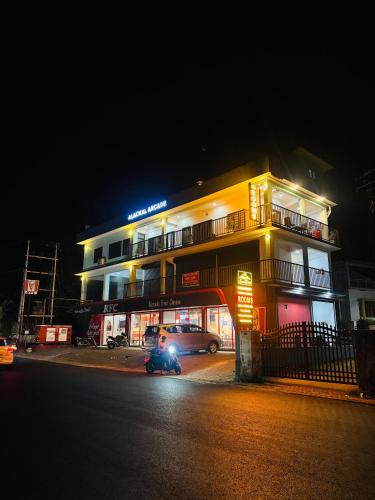 a building with a car parked in front of it at night at Enroute Delight Residency in Kotamangalam