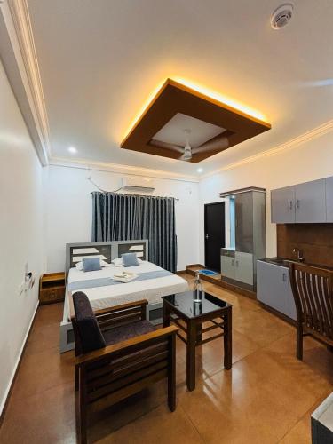 a bedroom with a bed and a table in a room at Enroute Delight Residency in Kotamangalam