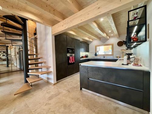 une cuisine avec un escalier au milieu d'une pièce dans l'établissement Le Panorama 301 - Penthouse d'exception, à Châtel