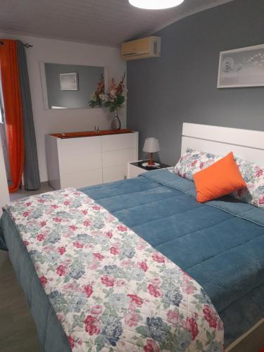 una camera da letto con un letto con un piumone blu di O Cantinho da Auzenda a Torre de Moncorvo
