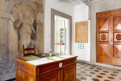 a room with a wooden desk and a door at Le Dimore del Seminario in San Miniato