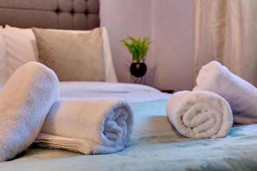 a pile of towels on top of a bed at Charming Semi-attached bungalow with free parking Pass the Keys in Cambridge