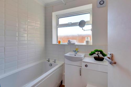 a bathroom with a tub sink and a window at Charming Semi-attached bungalow with free parking Pass the Keys in Cambridge