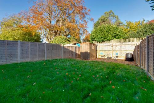 a backyard with a fence and green grass at Charming Semi-attached bungalow with free parking Pass the Keys in Cambridge