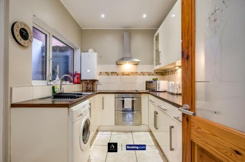 a kitchen with a washer and dryer in it at 2 Bedrooms House By Boyeilles Apartments Short Lets & Serviced Accommodation Belfast With Free Wifi in Belfast