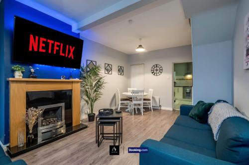 a living room with a blue couch and a tv at 2 Bedrooms House By Boyeilles Apartments Short Lets & Serviced Accommodation Belfast With Free Wifi in Belfast