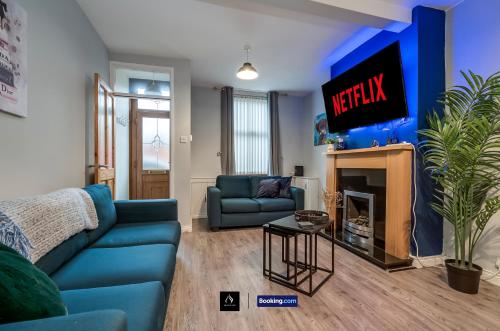 a living room with a blue couch and a tv at 2 Bedrooms House By Boyeilles Apartments Short Lets & Serviced Accommodation Belfast With Free Wifi in Belfast