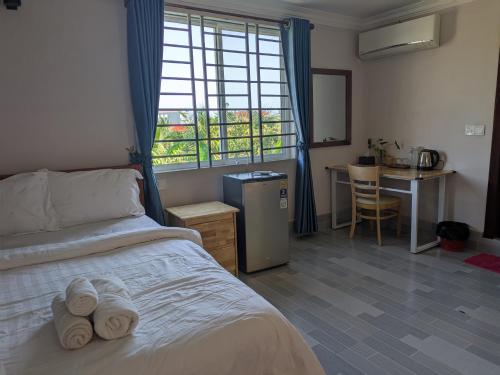 a bedroom with a bed with towels on it at Coconut Lodge in Kampot