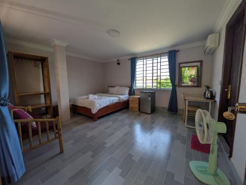 a bedroom with a bed and a large window at Coconut Lodge in Kampot