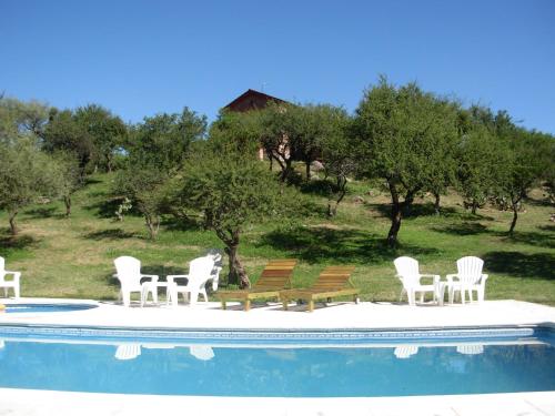 a group of chairs sitting next to a swimming pool at Complejo Arlington Village in Cortaderas