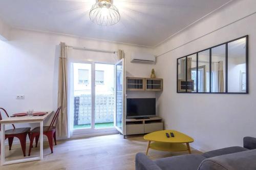 un salon avec un canapé et une table dans l'établissement Charmant studio rue Hérold - Wifi, AC, 2pers, à Nice