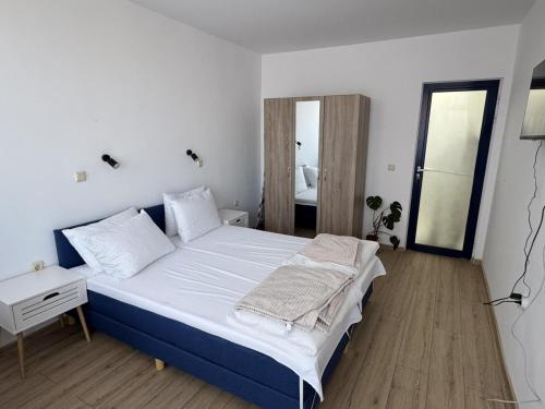 a bedroom with a large bed with white sheets at Apartment Bela in Burgas City