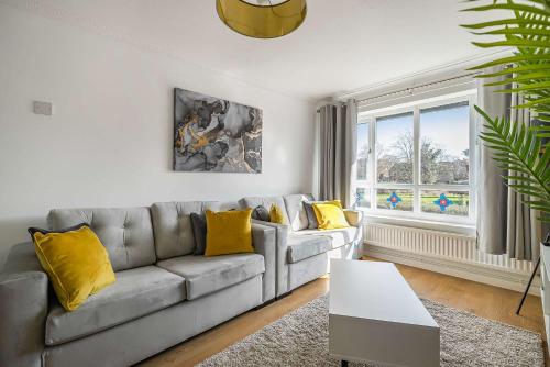 a living room with a gray couch and yellow pillows at Stylish 2BR Apartment near MCR Airport in Manchester
