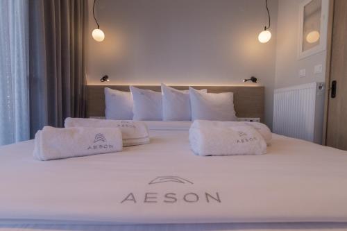 a white bed with two white pillows on it at Aeson Premium Living in Volos