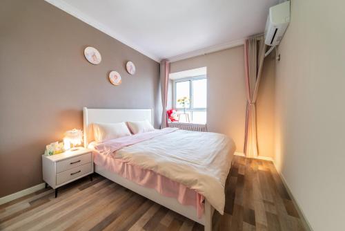 a bedroom with a bed and clocks on the wall at 连云港柒夕精品民宿 花果山店 in Ta-p'u