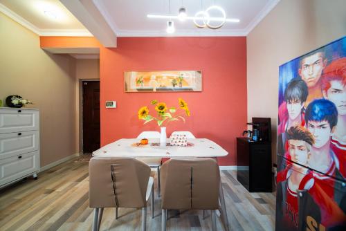 a dining room with a white table and a red wall at 连云港柒夕精品民宿 花果山店 in Ta-p'u