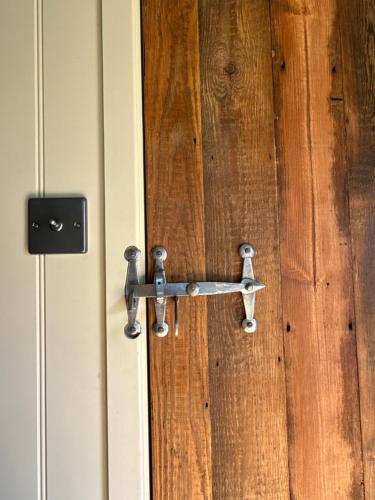 a metal door handle on a wooden door at 'Russet' Hut on fruit farm in Charsfield