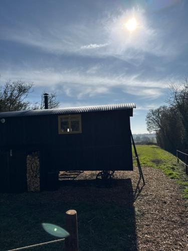 a black shed with the sun in the sky at 'Russet' Hut on fruit farm in Charsfield