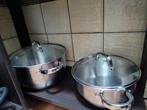 two large metal pots sitting on top of a shelf at Casa Jaruf CENTRO HISTÓRICO Parking Gratuito Patio petfriendly in Arcos de la Frontera