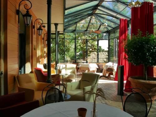 a restaurant with tables and chairs and a glass roof at Hotel De France in Mende