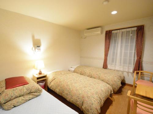 a hotel room with two beds and a window at Pension Avenue in Yamanakako