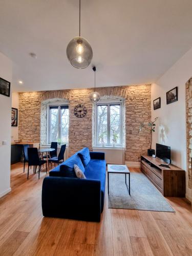 a living room with a blue couch and a table at Biały Kruk Apartamenty vis-a-vis Jasnej Góry 5a in Częstochowa