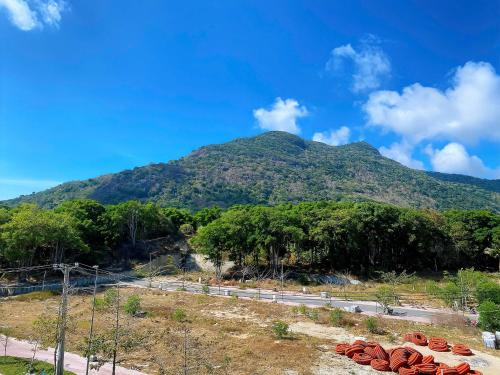 una montaña con árboles y una carretera en primer plano en Trung Hậu Hotel, en Con Dao