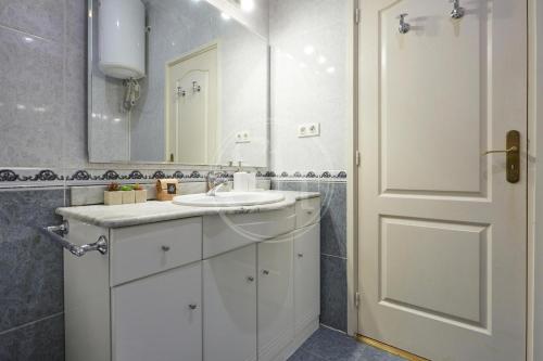 a bathroom with a white sink and a mirror at Bonito apartamento cerca de Plaza España in Barcelona