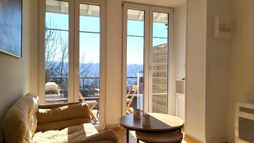 a living room with a couch and a large window at Le Bellevue - Beaux appartements avec vue splendide in Palaiseau