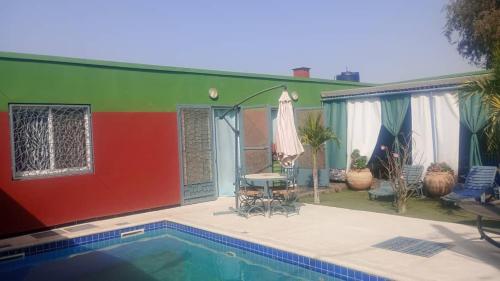 a house with a swimming pool in front of it at Keur youngar2 in Gandigal
