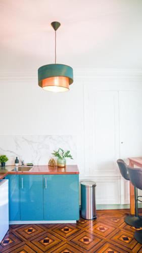 - une cuisine avec un îlot bleu dans l'établissement Le Canyon Rouen Centre by MyFrenchPAT Terrasse & Parking, à Rouen