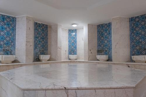 an empty room with a marble floor and blue tiles at Sural Hotel in Side